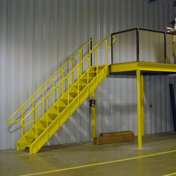 yellow Lapeyre industrial stairs lead to a second level in a factory