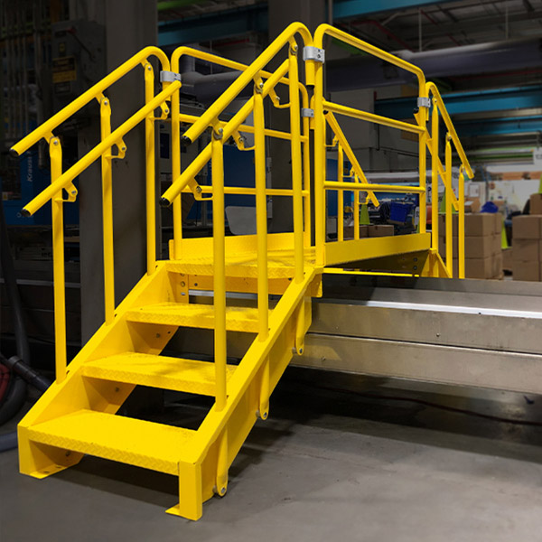 yellow Lapeyre crossover stairs bridging a conveyor