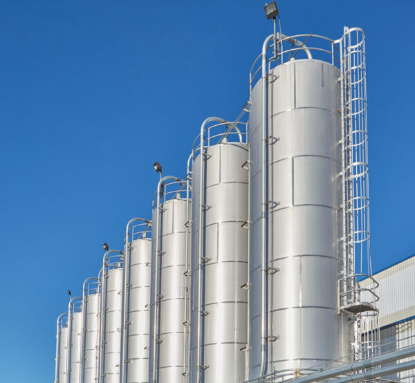 a line of silver silos against a bright blue sky